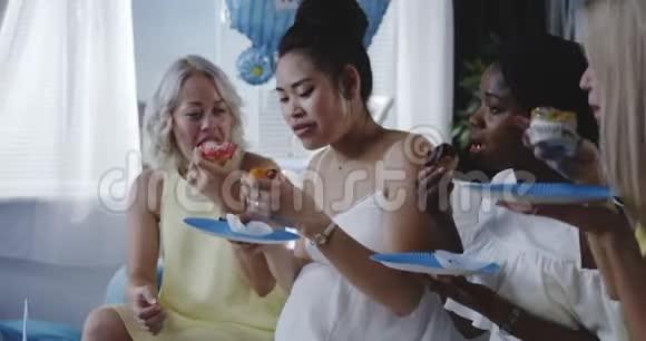 朋友们一边吃甜点一边庆祝年轻的母亲视频的预览图