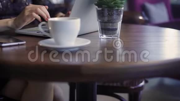 一个漂亮的女人在咖啡馆里用笔记本电脑工作一个快乐的女孩她收到了笔记本电脑键盘上的指纹视频的预览图