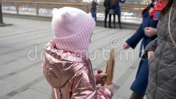 小女孩冬天在城里吃美味的热狗视频的预览图