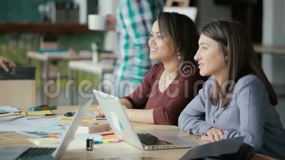 小创意商业团队在同事办公室工作两个女人交谈讨论想法使用笔记本电脑视频的预览图