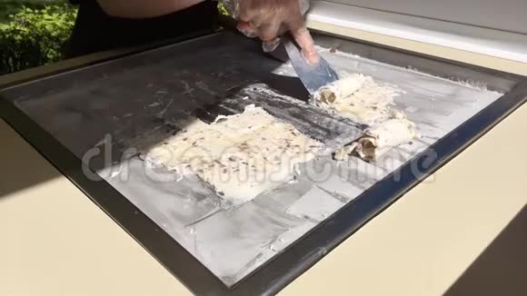 用香蕉和巧克力在冷冻锅中准备炒制的冰淇淋卷卷制冰淇淋手工制作冰淇淋视频的预览图