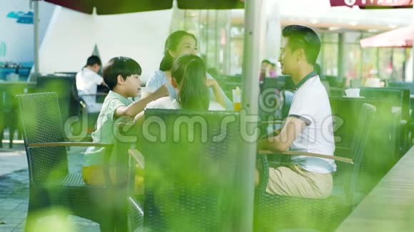 亚洲家庭在户外座位上喝酒和交谈享受家庭欢乐时光慢动作视频的预览图