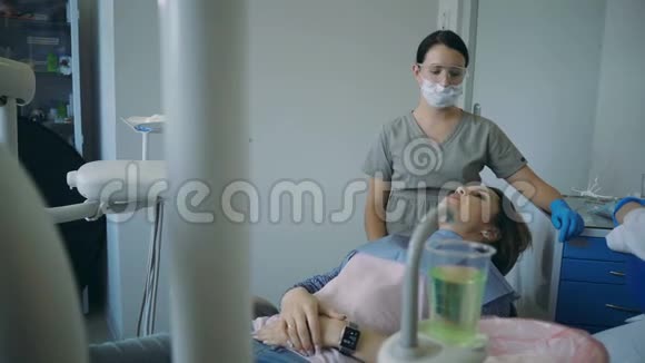 牙科治疗结束后医生举起牙科椅年轻女性口腔检查牙医视频的预览图