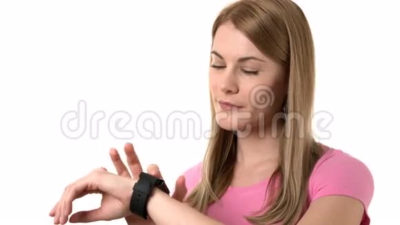穿着粉红色T恤的漂亮女人通过她的智能手表发送语音信息孤立的背景视频的预览图