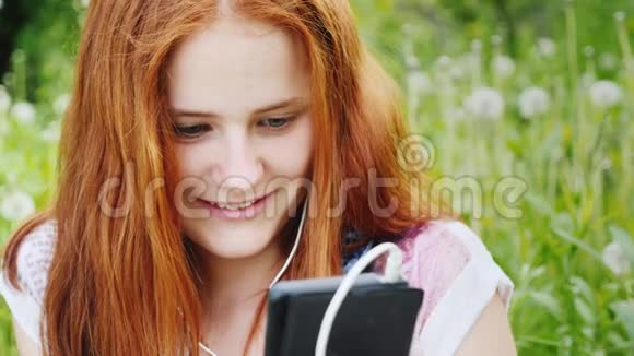 微笑的十几岁女孩享受电话在大自然中休息随时保持联系视频的预览图