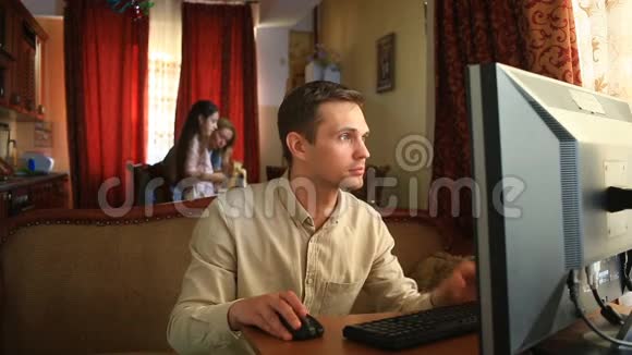 丈夫玩电脑游戏妻子和孩子在厨房里很忙她丈夫网络依赖视频的预览图