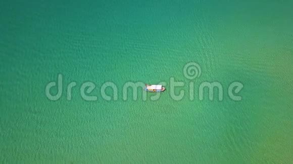 渔船航行在蓝色的海景在透明和绿松石中航行的飞行无人驾驶飞机的空中景观视频的预览图