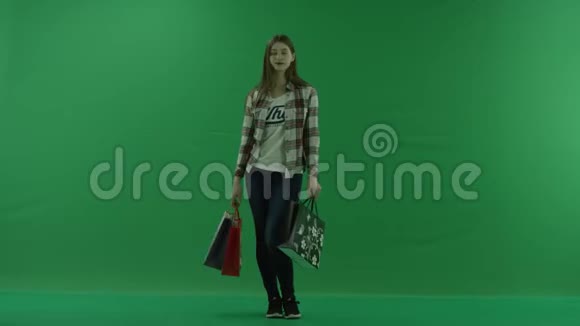 带着袋子的女孩看着绿色的屏幕视频的预览图