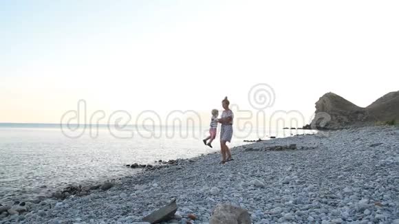 母亲和儿子正沿着海滩散步视频的预览图