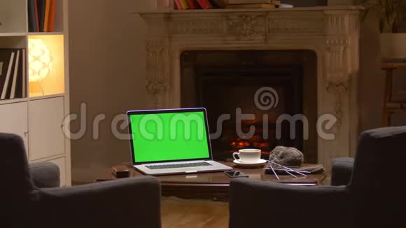 在舒适的酒店房间里办公桌上有一台模拟绿色屏幕笔记本电脑视频的预览图