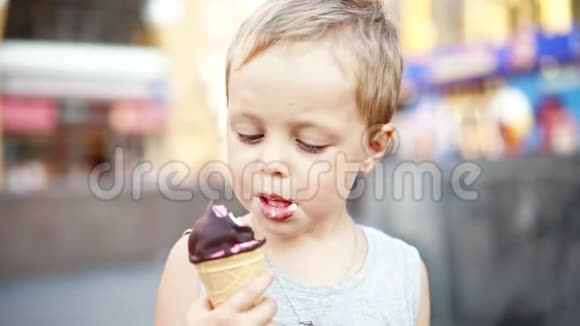 可爱的小男孩在夏天在蛋筒里舔冰淇淋视频的预览图
