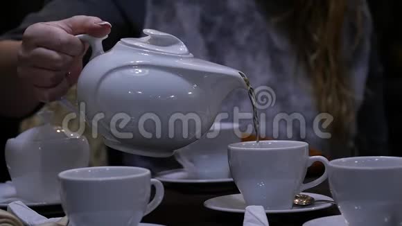 女人在咖啡馆里用白色杯子倒凉茶慢动作视频的预览图