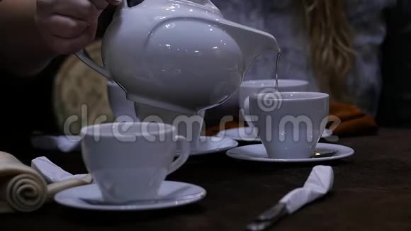 女人在咖啡馆里用白色杯子倒凉茶慢动作视频的预览图