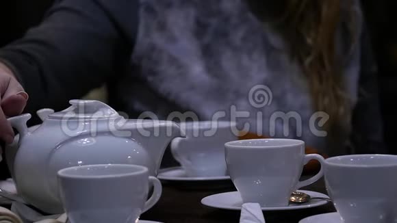 女人在咖啡馆的白色杯子里倒凉茶慢动作视频的预览图