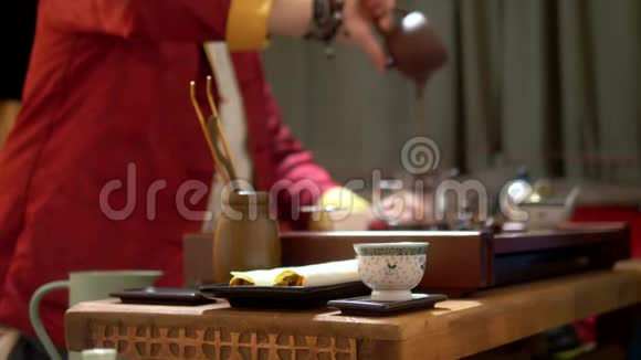 中国茶杯在锋利背景上模糊了中国传统茶饮的过程主人视频的预览图