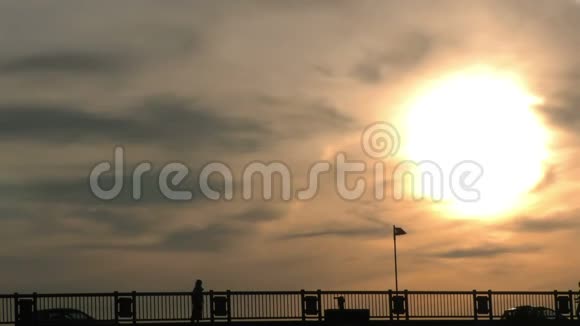 人们剪影在桥上和日落时经过视频的预览图