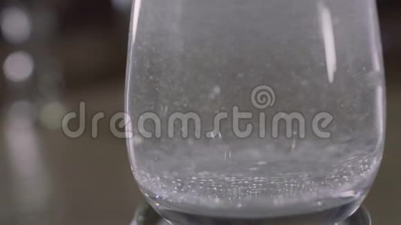 阿斯匹林溶解在玻璃与水闪闪发光的彩色灯视频的预览图