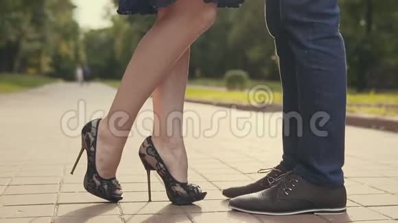 年轻夫妇站在城市里互相亲吻女人高兴地抬起脚趾视频的预览图
