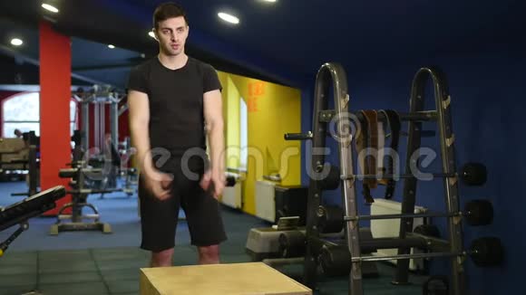 肌肉男在健身房做盒子蹲运动视频的预览图