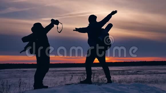 人们冬天的飞机剪影照片挥舞着手臂在天空中欢乐的雪阳光步行的游客组视频的预览图