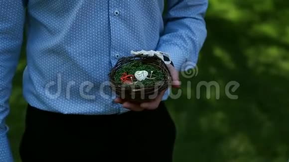婚礼戒指在一个小小的草篮在男人手视频的预览图