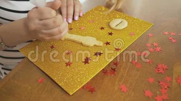 一只雌性的手用白釉装饰圣诞姜饼为节日餐桌做准备视频的预览图