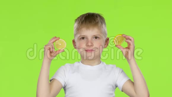 孩子们拿着柠檬片舔它们露出鬼脸绿色屏幕视频的预览图