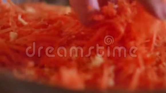 生胡萝卜是用葵花籽油在煎锅里煎的素食主义者在厨房里把食物胡萝卜磨碎视频的预览图