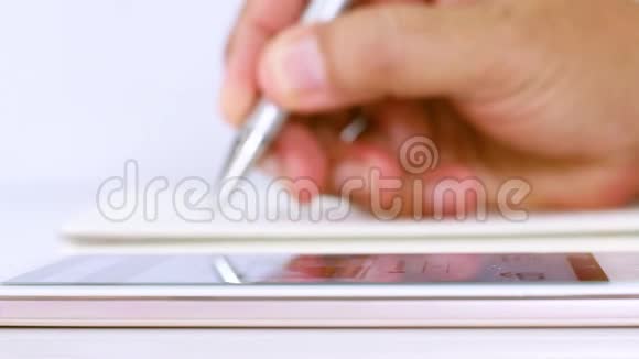 一个商人拿着笔摸着手机屏幕搜索商业数据视频的预览图