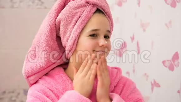 年轻女孩在浴室里用化妆品膏洗脸视频的预览图