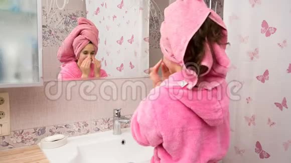 年轻女孩在浴室里用化妆品膏洗脸视频的预览图