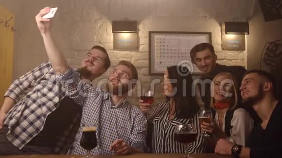 这群朋友正在吃自拍做滑稽的脸在足球酒吧的背景下喝啤酒这就是视频的预览图