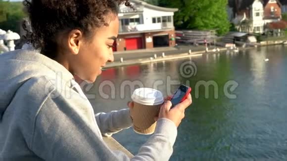 混血非裔美国少女女青年在桥上用电话视频的预览图