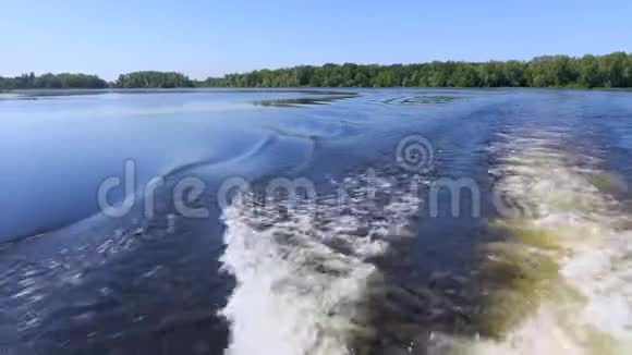 船尾的录像浪在水面上醒来夏天的河流或湖泊蓝天视频的预览图