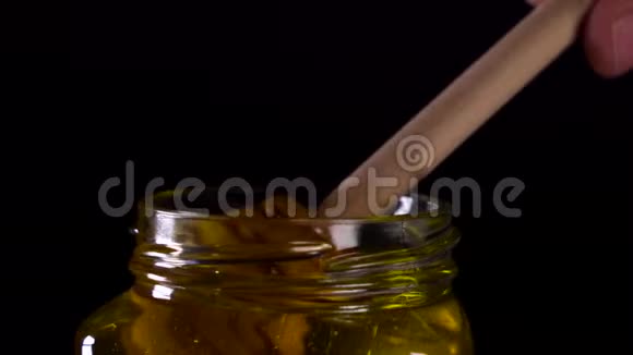 把美味的蜂蜜从一个罐子里滴出来视频的预览图
