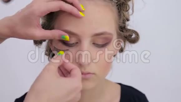 专业化妆师将假睫毛涂在模特眼睛上视频的预览图
