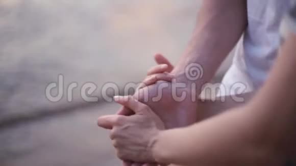 近景男女双手年轻夫妇站在海边沙滩上牵着手视频的预览图