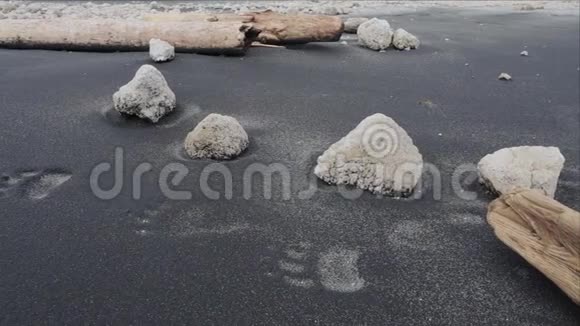 在白色悬崖边的黑色沙滩上留下足迹伊图鲁普岛视频的预览图