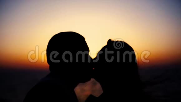 两个情人在晚上的背景下在湖边接吻的剪影库存宁静的浪漫时刻视频的预览图