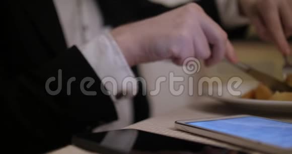 商人在餐馆吃饭使用平板电脑特写视频的预览图
