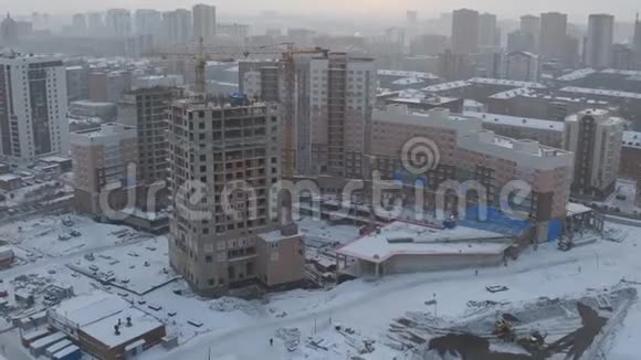 冬季城市景观未完工公寓楼建筑工地鸟瞰视频的预览图