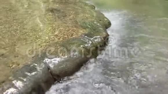 美丽清澈的水流穿过天然的山岩视频的预览图