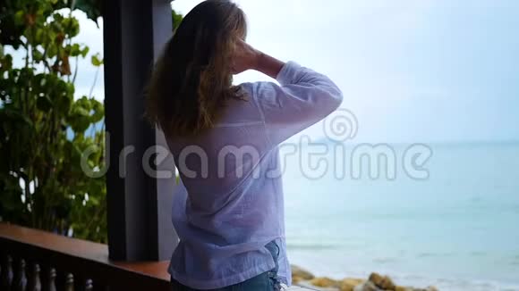 女孩站在露台上望着大海视频的预览图