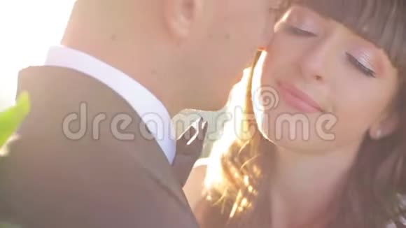 新婚夫妇在户外摸鼻子的特写照片一对相爱的新婚夫妇闭着眼睛视频的预览图