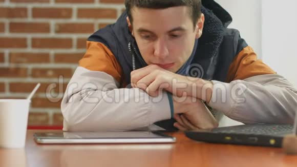 无聊的学生在平板电脑上阅读坏消息独自在咖啡馆里视频的预览图