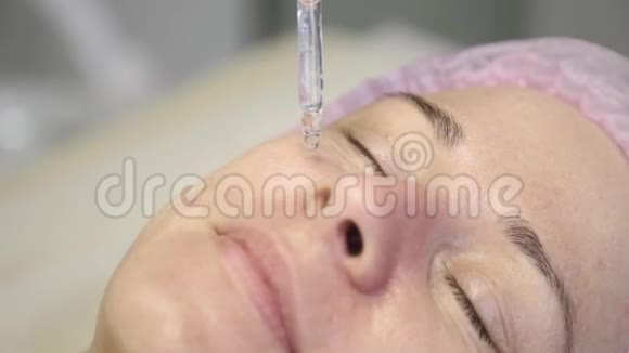 美容护肤的特写美容师在女性的脸上涂油面具视频的预览图