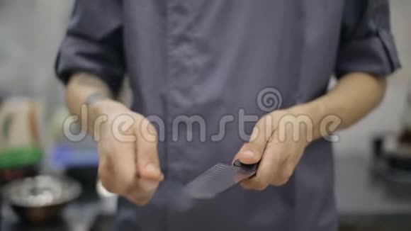 男厨磨刀在商业厨房中的应用视频的预览图