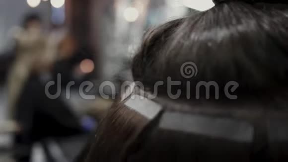 理发师把人造头发贴在真东西上发延伸的过程4K视频的预览图