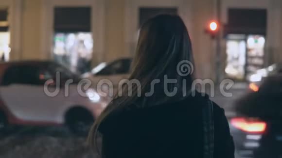 傍晚时分一位年轻的黑发女子站在交通道附近环顾四周视频的预览图