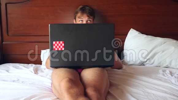 快乐英俊的男人在明亮的卧室里工作4k慢动作视频的预览图